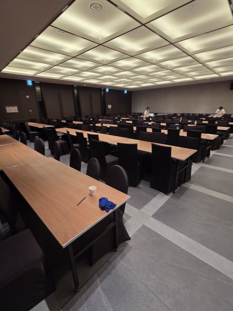 테이블과 의자를 열에 맞춰 정렬한 강당