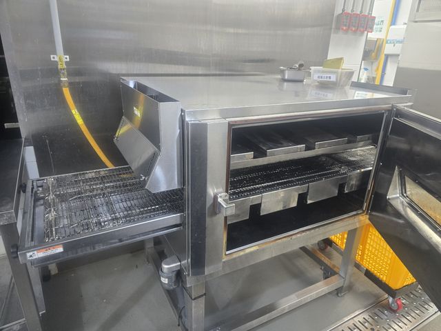 도어를 열어 둔 컨베이어 오븐과 벨트 세척 현장